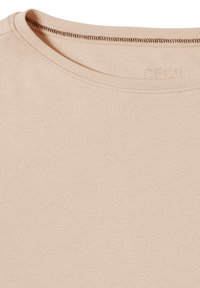 T-shirt beige ajusté avec un col rond, des coutures étroites au niveau du col et une texture lisse et extensible. Nom de la marque "Cecil" embossé.