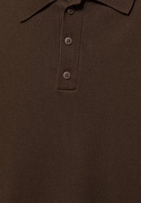 Polo marrone lavorata a maglia con colletto e tre bottoni abbinati lungo una patta a coste.