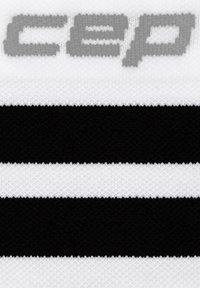 Tessuto a maglia bianco e nero con tre strisce orizzontali; logo "cep" grigio prominente nella parte superiore. Aspetto strutturato con una finitura morbida.