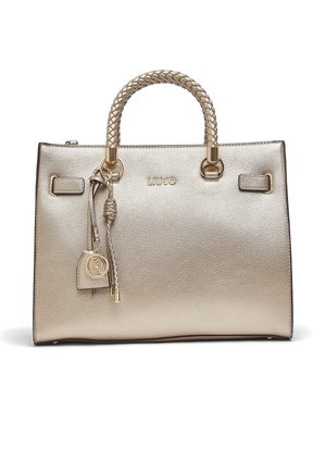 Sac à main en cuir doré métallisé avec poignées tressées, anneaux dorés et breloque à glands tressés suspendue ornée d'un médaillon rond avec logo.