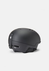 Casco negro con un diseño aerodinámico y elegante. Presenta aberturas de ventilación, superficie texturizada y una correa segura en la parte posterior.