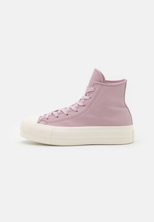 High-top sneakers in soft lavender leather with flat laces, a white rubber sole, and textured toe cap. Sleek design with minimal stitching.