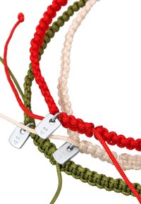 Tre flätade armband i rött, grönt och beige, med silverbrickor märkta "925." Materialet är slitstark snodd med en strukturerad finish.