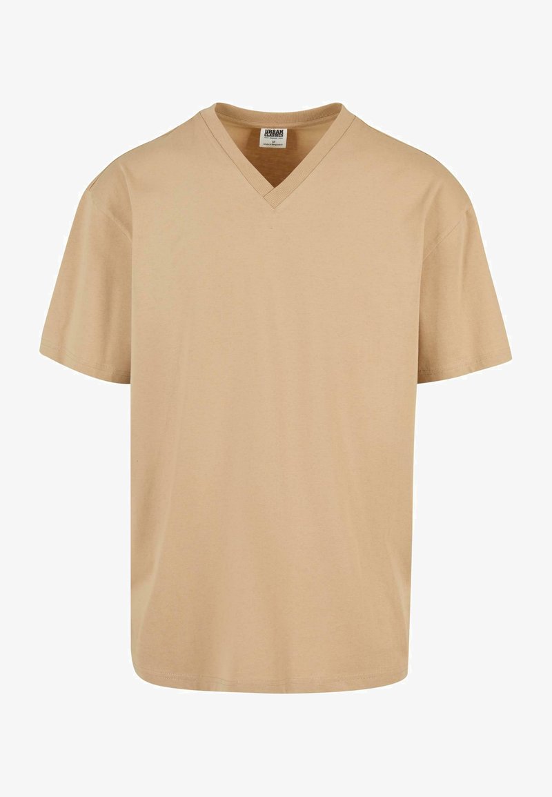 Beżowa koszulka V-neck, krótki rękaw, wykonana z miękkiej bawełny. Posiada luźny krój oraz minimalne przeszycia przy dekolcie i dolnym brzegu.