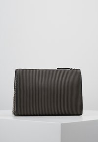 Czarna plisowana kopertówka z zamknięciem na zamek, z bocznym akcentem łańcucha. Gładka tekstura i usztywniony prostokątny kształt.