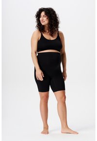 Zwarte geribde bralette en shorts tot halverwege de dijen set. Zacht, rekbaar materiaal. Bralette met dunne bandjes, shorts met een brede tailleband en subtiele naden.