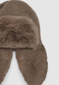 Brązowa dzianinowa czapka z obramowaniem z futerka i nausznikami. Materiał jest miękki o jednolitym, ziemistym kolorze. Czapka ma zaokrąglone krawędzie i dobrze dopasowuje się do głowy.