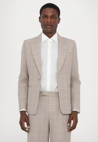 Šviesiai pilkas kostiumas su rožiniu languotu raštu, figūriškai pritaikytas, vieno mygtuko švarkas, su išlenktais apykaklės kraštais, derinamas su balta lininė marškinė.