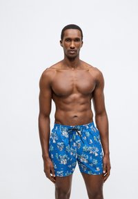 Zilas peldbikses ar krāsainu jūras motīvu, kurā attēloti buru laivas un palmām. Elastīga josta ar regulējamu auklu.