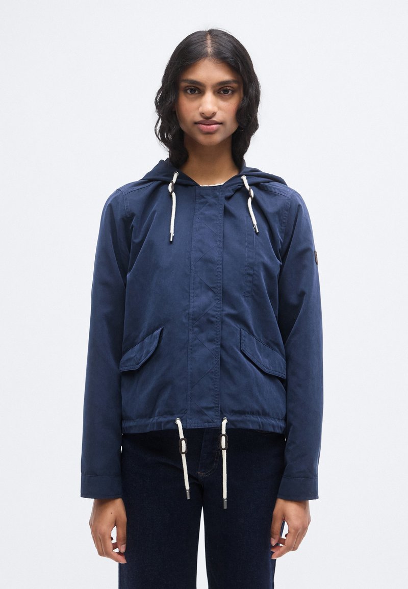 Μπλε ναυτικό μπουφάν με κουκούλα από ελαφρύ ύφασμα, με δύο μπροστινές τσέπες, ρυθμιζόμενα κορδόνια και τσέπη με φερμουάρ στο πλάι.