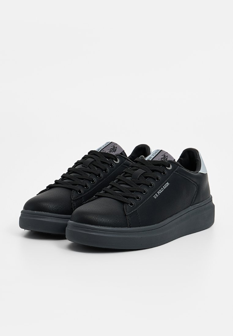 Zapatillas de cuero negro con un acabado texturizado, punta redonda, diseño con cordones y suela acolchada. Presentan un acento en azul claro en el talón.