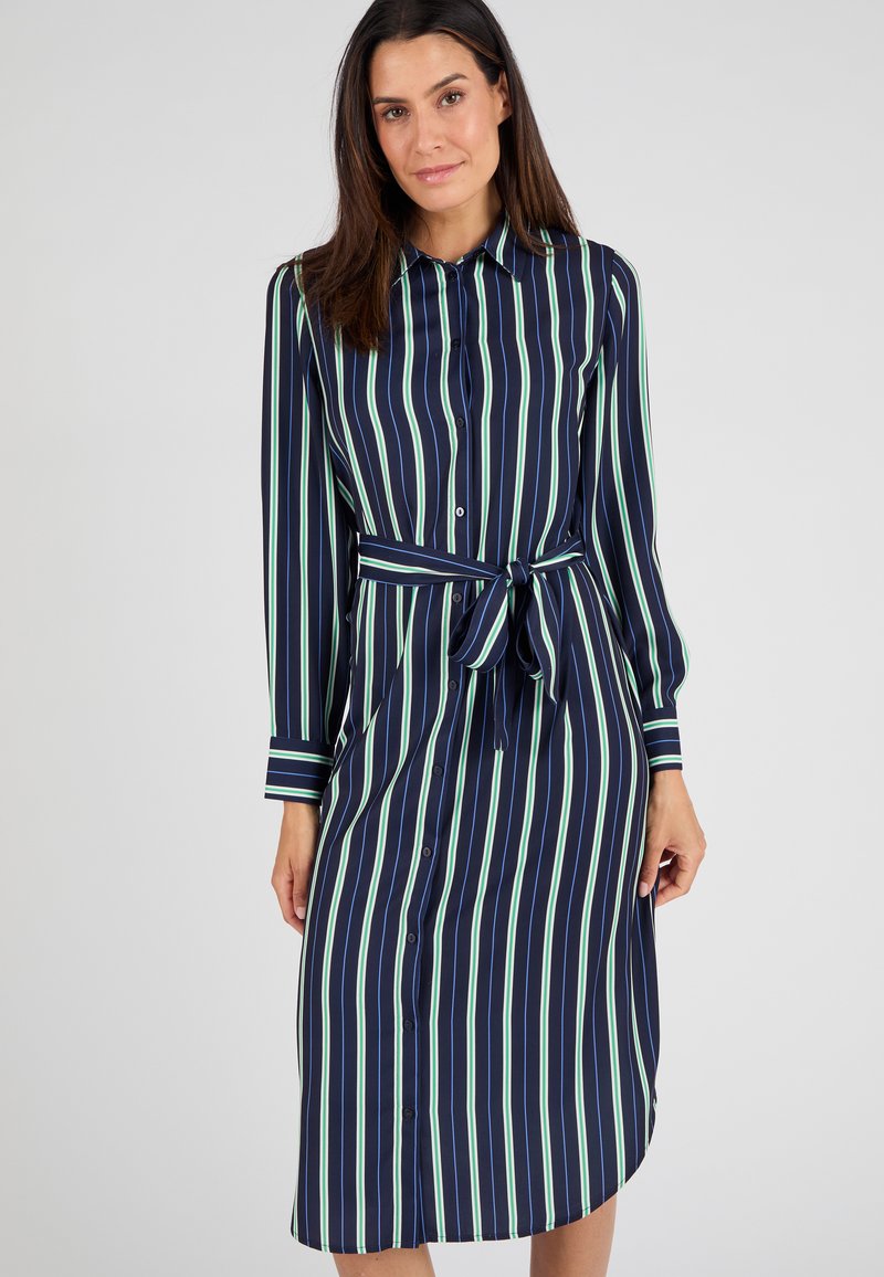 Abito camicia blu navy a maniche lunghe con righe verticali verdi e bianche, apertura frontale con bottoni e vita aderente per una silhouette definita.
