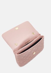 Pink quilted synthetic leather handbag with gold-tone hardware, snap closure, and a black interior lining featuring a zipped pocket.