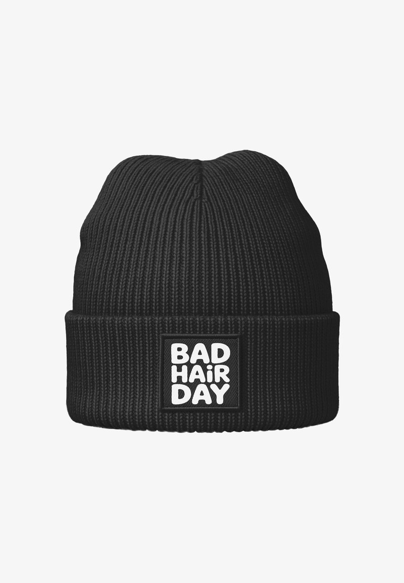 Black knit beanie with ribbed texture, featuring a folded cuff and a square patch displaying the text "BAD HAIR DAY" in bold white letters.