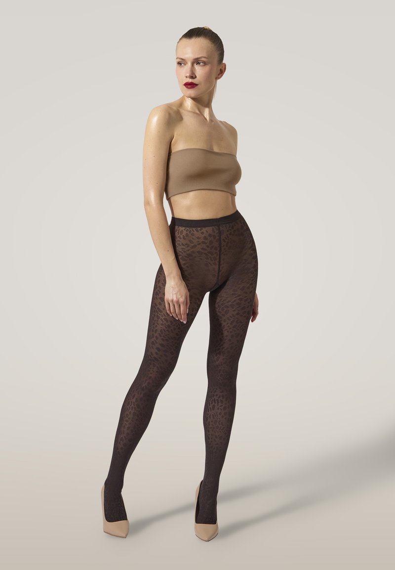 Leopardmönstrade strumpbyxor med ett svart och brunt mönster, tillverkade av genomskinligt material. Matchas med en naken strapless topp och neutrala klackar.