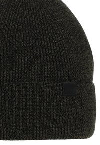 Berretto lavorato a maglia di un verde oliva scuro con risvolto e una piccola toppa nera rettangolare sul lato.