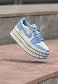 Μπλε και λευκά sneakers πλατφόρμας με λείο δερμάτινο επάνω μέρος, διάτρητη μύτη και στρωμένο πέλμα με μπλε λεπτομέρειες και υφασμένους ριγέ σχεδιασμούς.