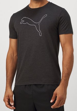 Homme portant un t-shirt gris foncé à manches courtes avec un grand contour blanc d’un puma sautant sur la poitrine.