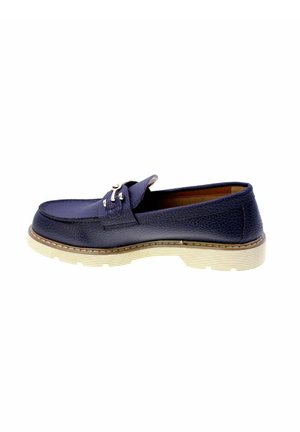 Mocassino in pelle blu scuro con suola in gomma beige e dettaglio fibbia argento, mostrato di profilo su sfondo bianco.