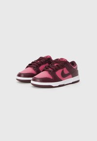 Nike sneakers with a maroon and pink leather upper, featuring a perforated toe, white midsole, and matching laces.