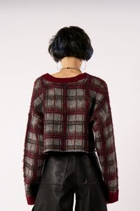 Afklippet ternet sweater i bourgogne og grå, med en fuzzy tekstur og ribbet krave. Bæret med sorte læderbukser.