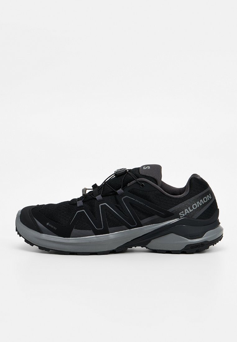 Zapatilla de trail running Salomon en negro y gris con Gore-Tex, sistema de cordones rápidos y suela texturizada para agarre fuera de carretera.