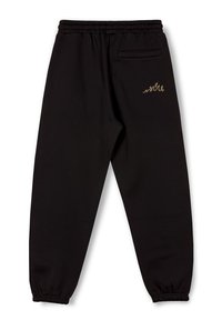 Schwarze Jogginghosen aus einem weichen Stoff, mit einem elastischen Bund, gerippten Bündchen und einem kleinen, goldenen Stickdetail auf der Rückseite.