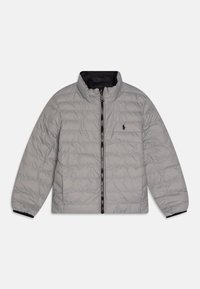 Ljust grå pufferjacka med hög krage, dragkedjestängning och svart innertyg. Har quiltad textur och en liten logotyp på bröstet.