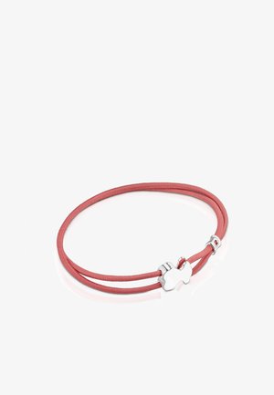 Pulsera de doble cordón rosa con un cierre en forma de pieza de rompecabezas de plata y un pequeño acento plateado sobre una superficie blanca reflectante.