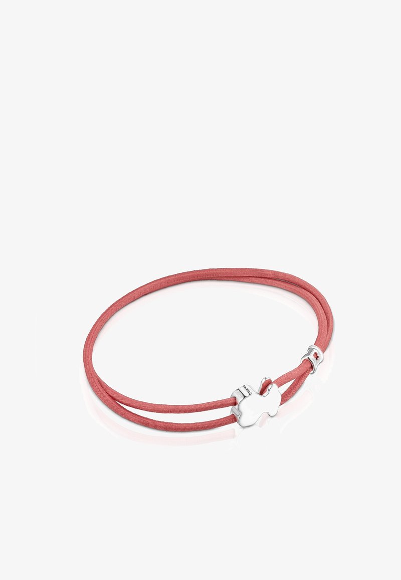 Różowy podwójny sznurek bransoletki z zapięciem w kształcie srebrnego puzzli i małym srebrnym akcentem na refleksyjnej białej powierzchni.