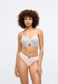 Hallhalline bralette õhukeste rihmadega ja brändiraamiga; koos helesiniste aluspükstega, millel on väike logotaga. Sile kangas ja keha lähedane disain.