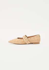 Pantof bej cu vârf ascuțit, din material suede, cu bijuterii decorative din aur și o curea pentru gleznă cu detaliu de cataramă rotundă.