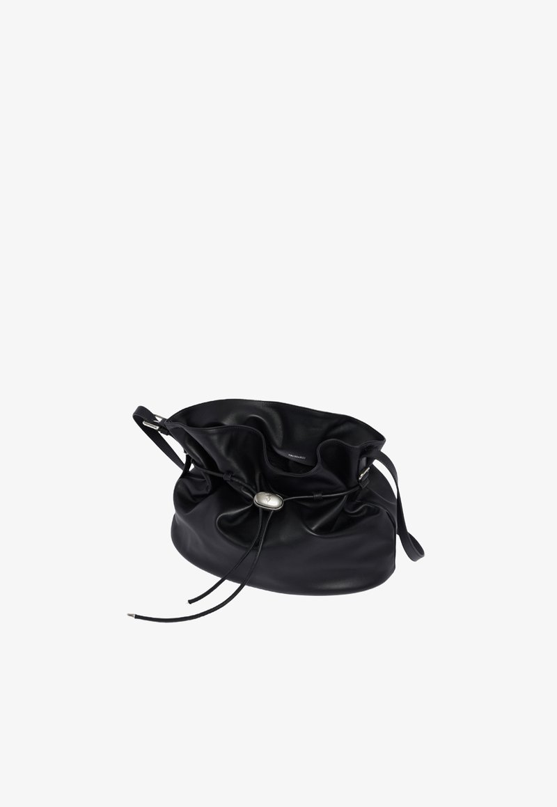 Černá kožená kabela ve tvaru kýble s nařaseným vrškem, zavíráním na šňůrku a stříbrným akcentem uprostřed. Hladká textura a minimalistický design.