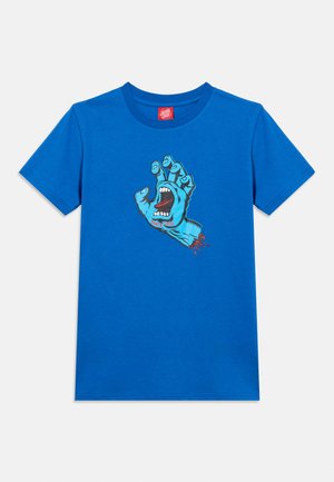 Svetlo modra majica s kratkimi rokavi, na kateri je grafika vpijoče modre roke z odprtimi usti in napisom "Santa Cruz" na zapestju.