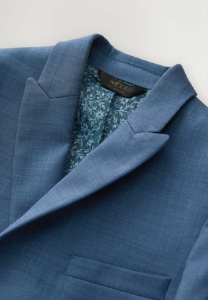 Blå kavaj med en strukturerad krage och ett innerfoder med blommönster. Har en enkel bröstficka och texturerat tyg.