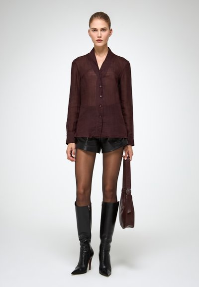 Burgundy sheer button-up shirt, black leather shorts, knee-high black boots, and a burgundy leather handbag. Smooth texture, tailored fit.