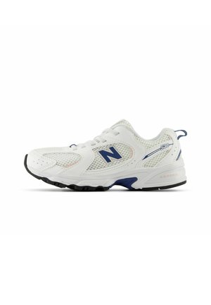 Hvid atletisk sneaker med mesh-paneler, blåt "N"-logo på siden, blå accenter og sort ydersål, vist i venstre sideprofil.