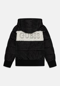 Kurtka puchowa z czarną zewnętrzną warstwą, białym poziomym paskiem i logo "GUESS". Posiada kaptur oraz elastyczne mankiety dla lepszego dopasowania.