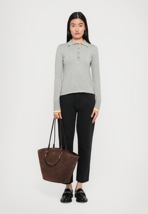Gray long-sleeve polo with yellow accents, black jeans, and a dark brown tote bag with handles, worn with black loafers.