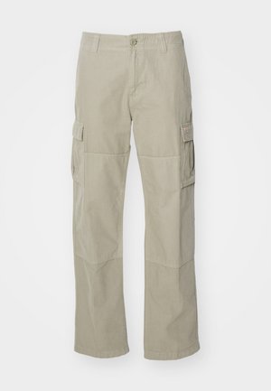 Pantalons cargo en kaki clair, fabriqués en coton, présentant des jambes larges, deux poches latérales et une fermeture à bouton à la taille. Texture lisse.
