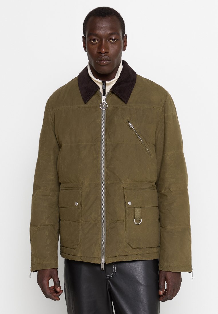 Oliwkowa pikowana kurtka z brązowym kołnierzem, zapinana na zamek z przodu, z kieszeniami bocznymi z zapięciami typu nap i dekoracyjnym pierścieniem.