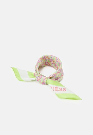 Jedwabny szalik z różowo-zielonym geometrycznym wzorem, zawiązany na supeł, z napisem „GUESS” na zielono-białym pasiastej końcówce.