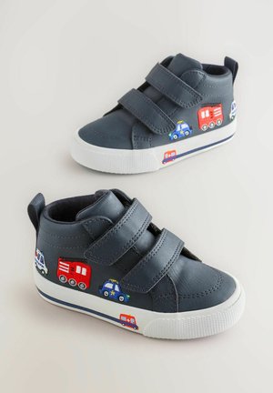 Marineblaue Kindersneaker mit doppelten Klettverschlüssen, weißen Sohlen und gestickten Designs von Einsatzfahrzeugen an den Seiten.