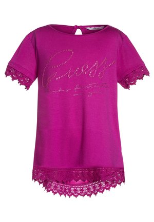 Lyserød kortærmet piget-shirt med blondekant på ærmer og forneden, 'Guess' med rhinsten på brystet, knaplukning med nøglehul bagpå.