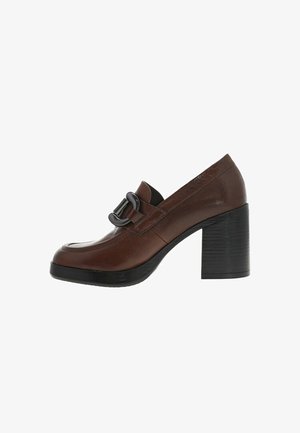Chaussure à talon en cuir marron avec un bout arrondi, dotée d'une boucle décorative et d'un talon noir texturé, conçue pour le confort et la stabilité.