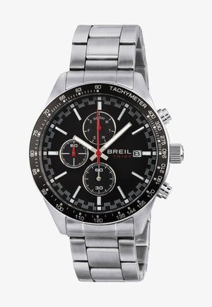 Montre en acier inoxydable argenté avec un cadran noir, fonctions chronographe, accents rouges et échelle tachymétrique. Comprend trois sous-cadrans.