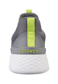 Szare sneakersy z teksturowaną górą z siateczki, płaskimi sznurowadłami, jasną zieloną pętelką oraz białą amortyzowaną podeszwą. Logo "GIESSWEIN" w kolorze zielonym na pięcie.