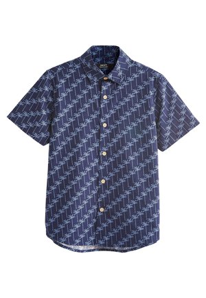 Koszula na krótki rękaw z granatowej tkaniny, ozdobiona jasnoniebieskim wzorem z palm na całej powierzchni oraz drewnianymi guzikami z przodu.