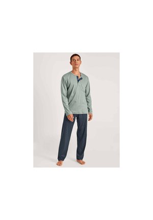 Lichtgroene blouse met lange mouwen en een notch-kraag en zak, gecombineerd met marineblauwe gestreepte pyjamabroek. Zachte stof, ontspannen pasvorm.