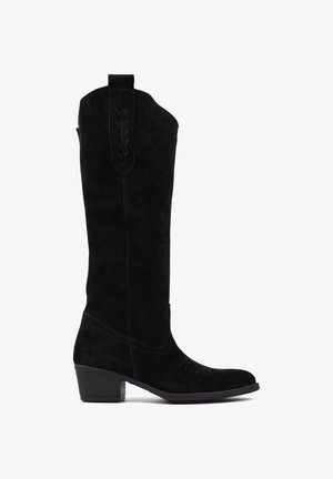 Czarne zamszowe wysokie kozaki na kolano z okrągłym noskiem, niskim blokowym obcasem, dekoracyjnym przeszyciem wzdłuż boków i pętlą jako akcentem na górze.